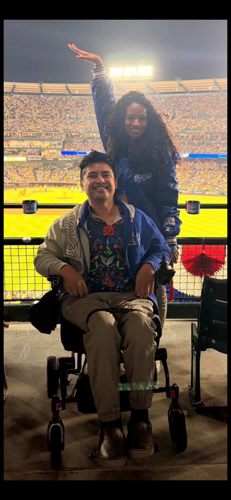 Miguel smiling from accessible seating at a baseball game