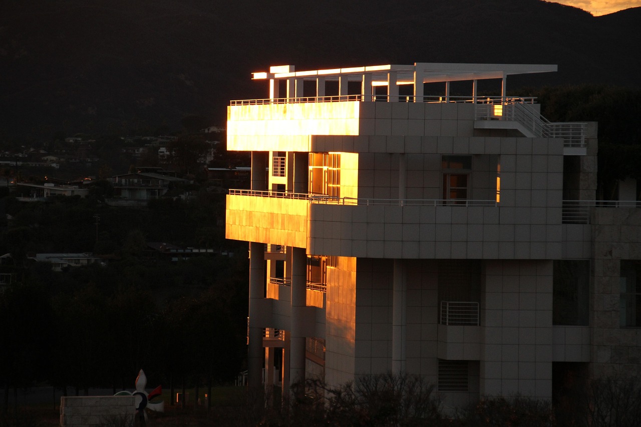 The Getty Center buildings catching low evening light, with dark hills behind.