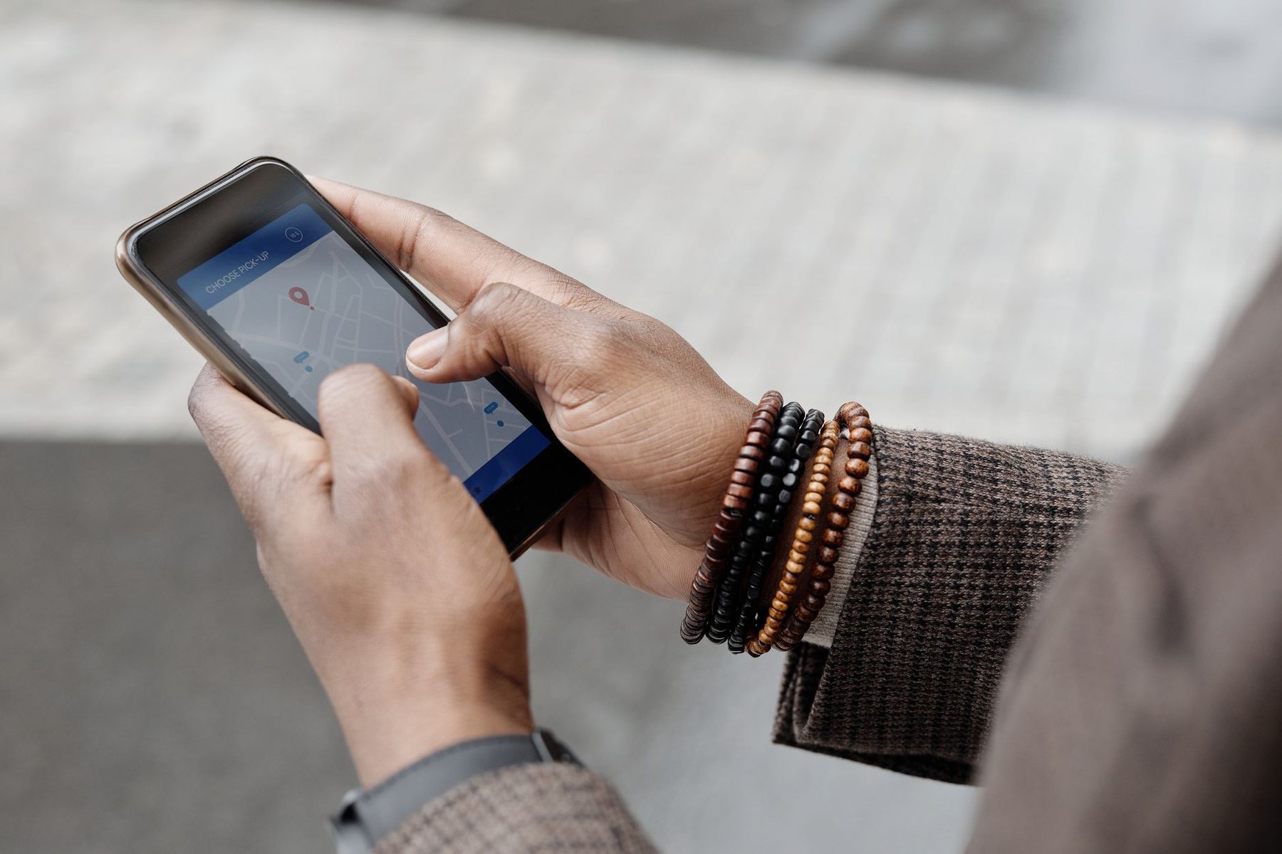 Hands holding a smartphone showing a street map while standing outdoors