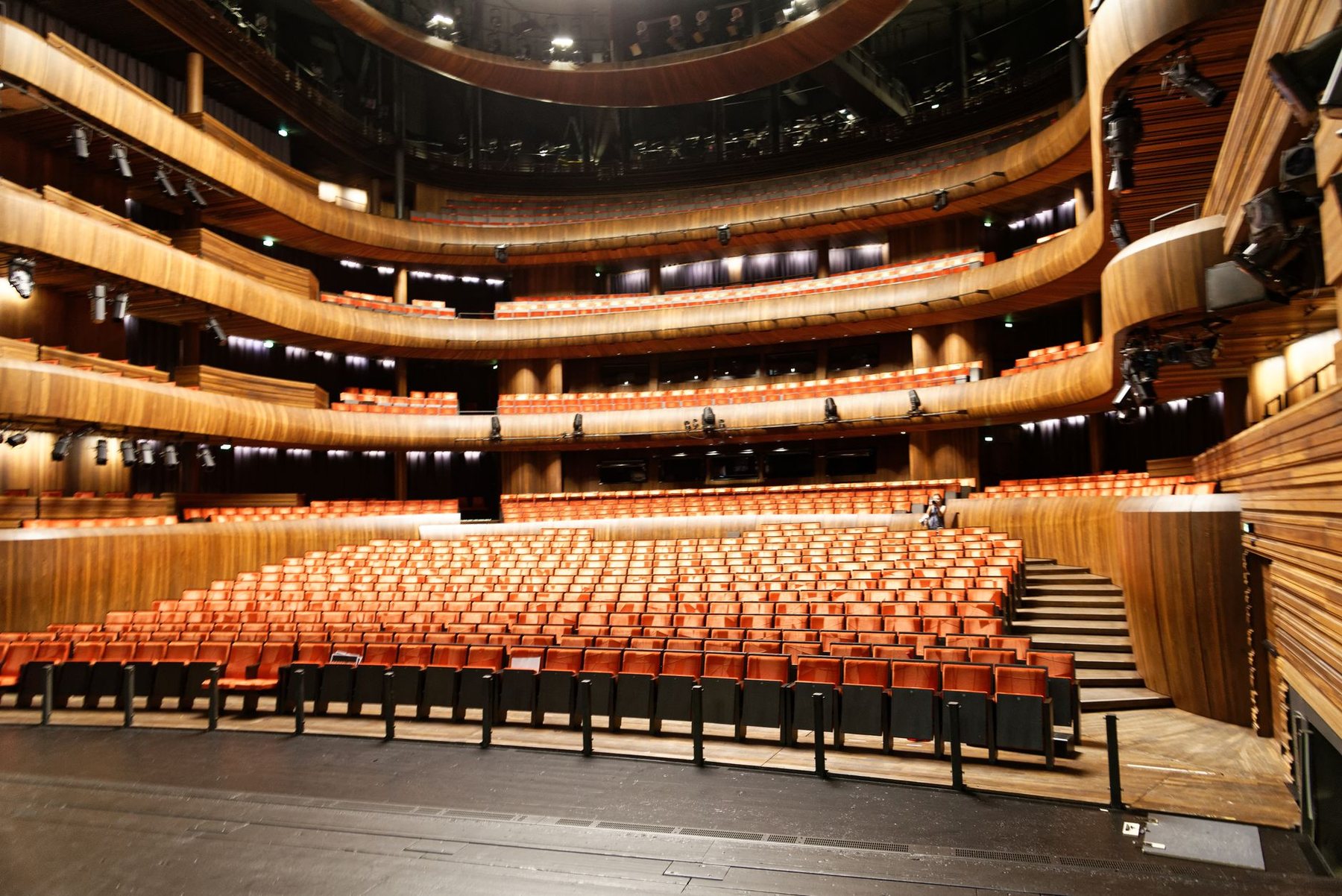 Interior of a large concert hall seen from a balcony, showing tiered seating and curved side galleries