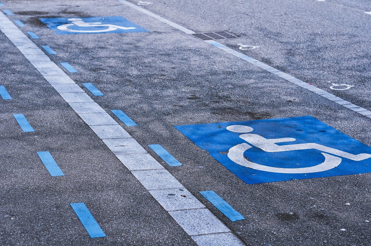 Accessible parking spaces marked with the wheelchair symbol and blue-striped access aisles in a parking lot