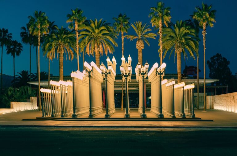 The Urban Light lamppost installation lit up at night outside LACMA in Los Angeles