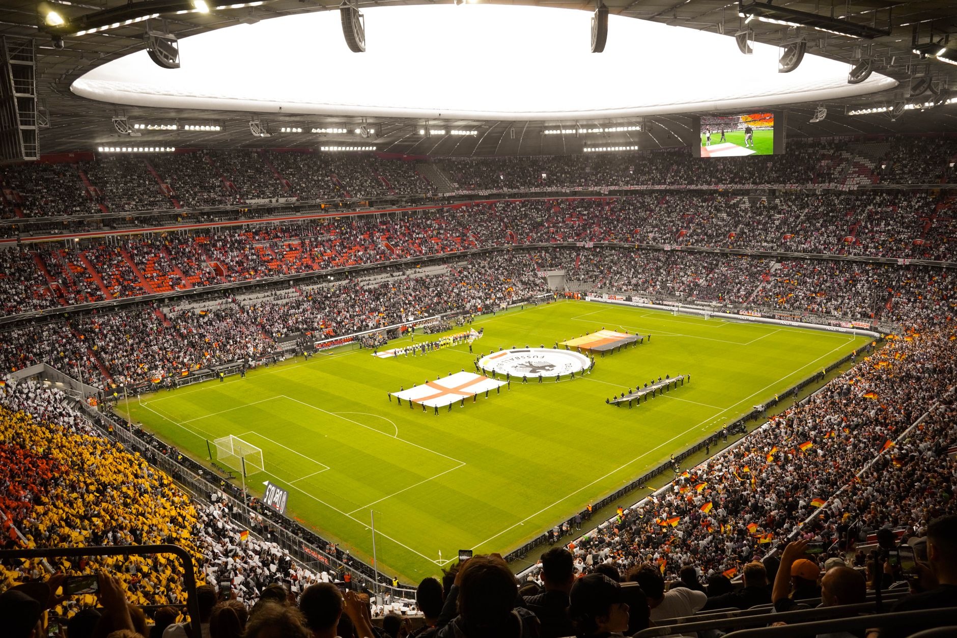 A packed stadium at night with fans filling every level around a floodlit field
